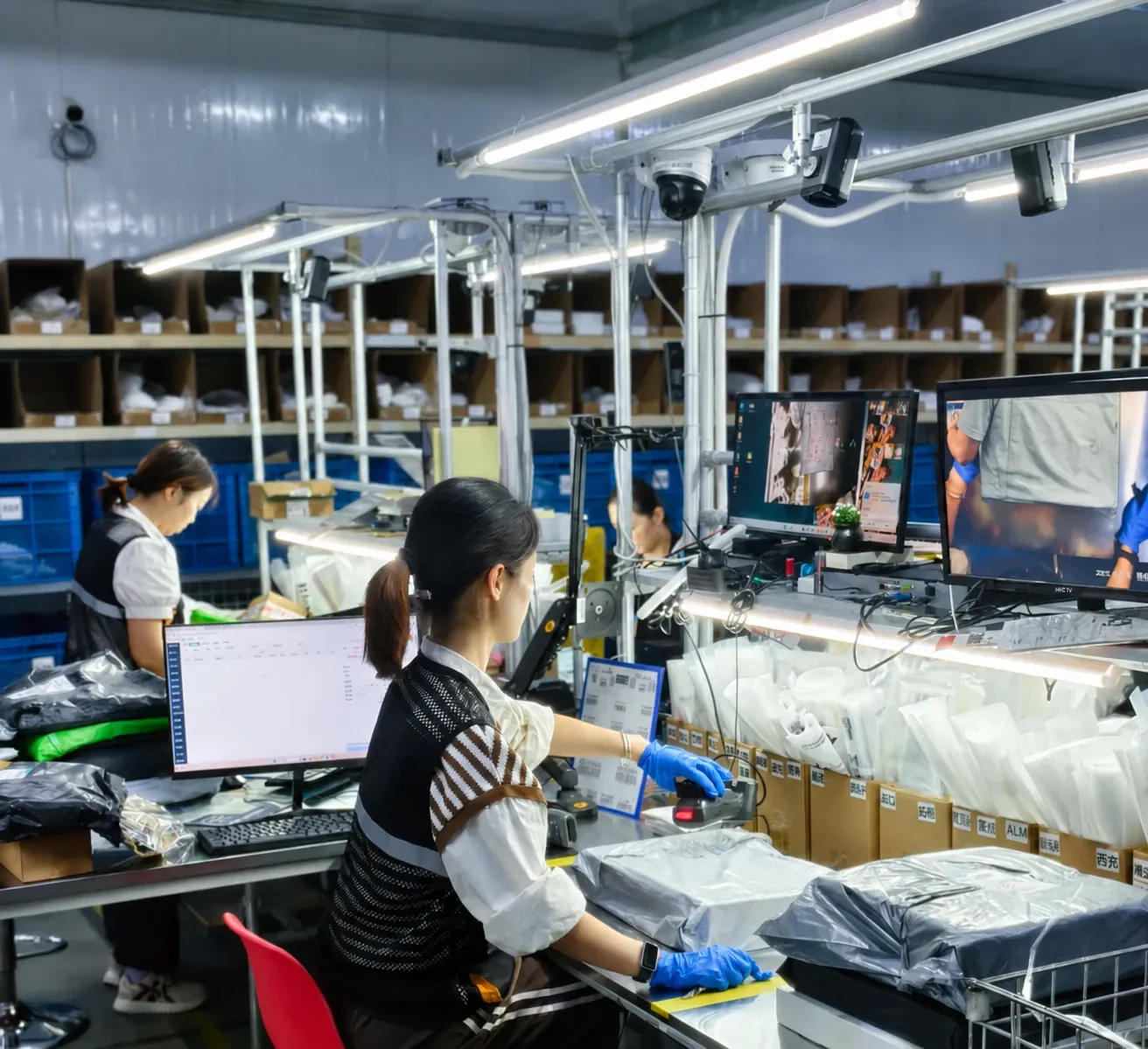 Worker checking garments at a warehouse bench