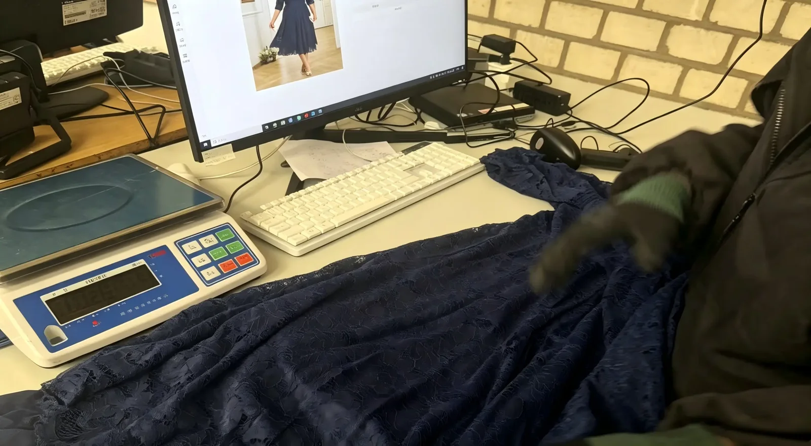 Returned garment being reviewed at a computer workstation